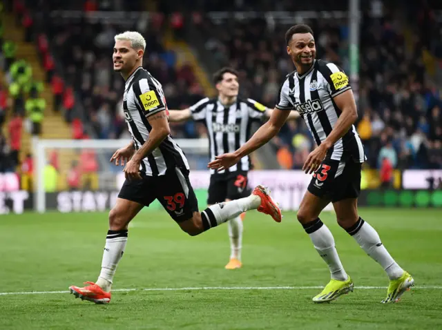 Bruno Guimaraes of Newcastle United celebrates scoring his team's third goal with teammate Jacob Murphy during the Premier League match between Burnley FC and Newcastle United