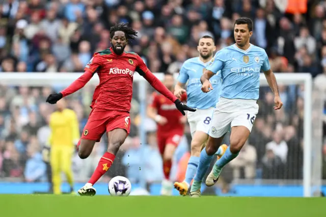 Boubacar Traore of Wolverhampton Wanderers runs with the ball whilst under pressure from Rodri of Manchester City during the Premier League match between Manchester City and Wolverhampton Wanderers