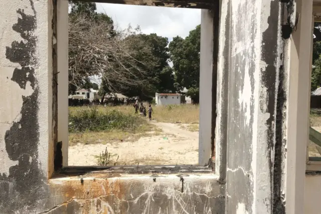 Children are seen through a broken window in Palma, Mozambique - September 2022