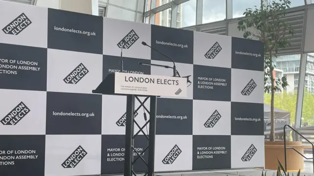 An empty podium is seen with London Elects in the background