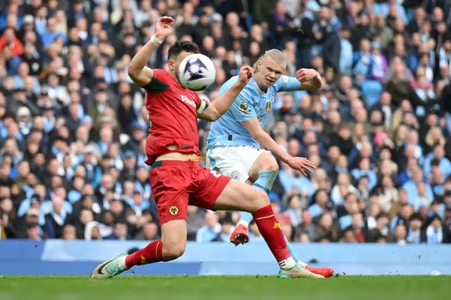 Max Kilman of Wolverhampton Wanderers attempts to defend as Erling Haaland of Manchester City scores his team's fourth goal during the Premier League match between Manchester City and Wolverhampton Wanderers