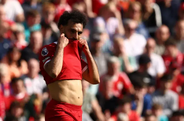 Salah lifts up his shirt