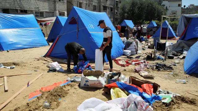 Two men picking up their belongings from the ground