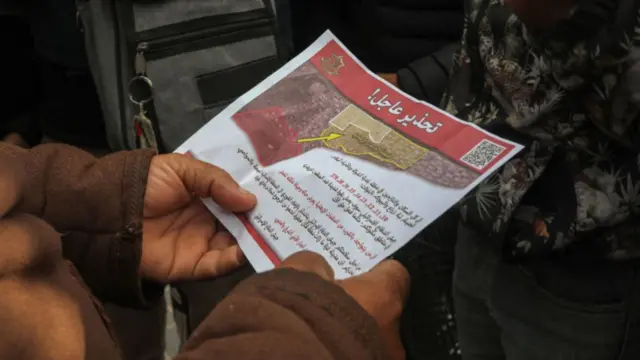 Red flier held in person's hands