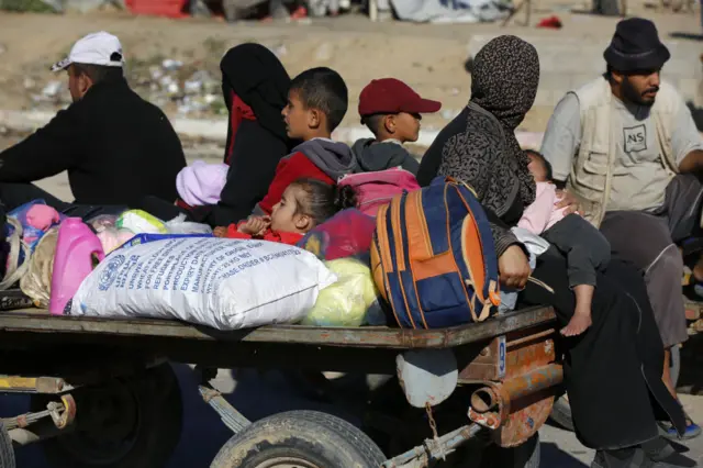 Displaced Palestinians arrive with their belongings in Khan Yunis, to the north of Rafah