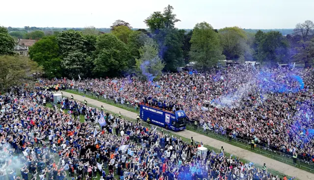 An aerial photograph of Ipswich Town promotion celebrations as an open-top bus enters Christchurch Park