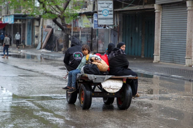 Palestinians can be seen on the roads leaving Rafah with a small number of belongings, 6 May 2024