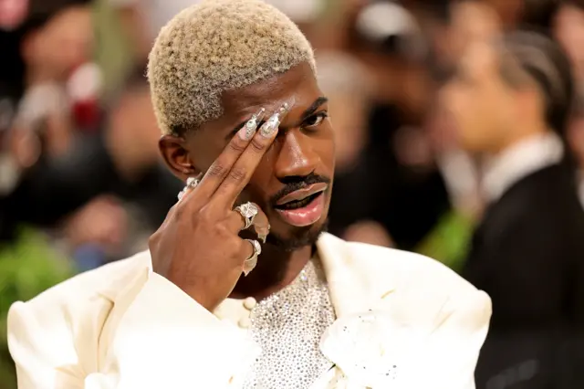 A Black man shows off his sculpted nails