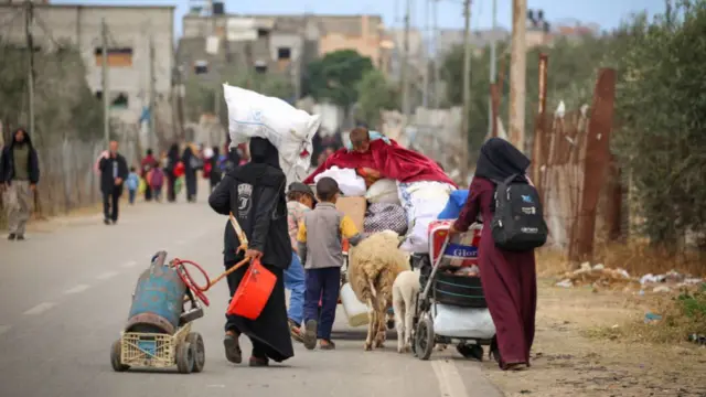 Displaced Palestinians in Rafah in the southern Gaza Strip carry their belongings as they leave following an evacuation order by the Israeli army on May 6,