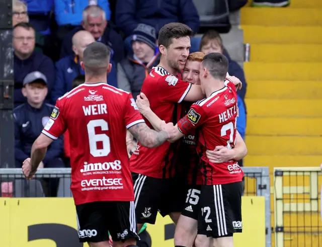 He's in there somewhere! Jarlath O'Rourke is congratulated after equalising for Crusaders