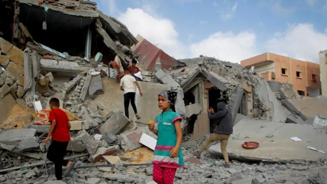 Palestinian children inspect the site of an Israeli strike on a house in Rafah