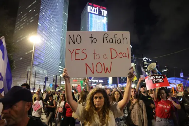 Protester with a sign saying 'no to Rafah, yes to a deal now'