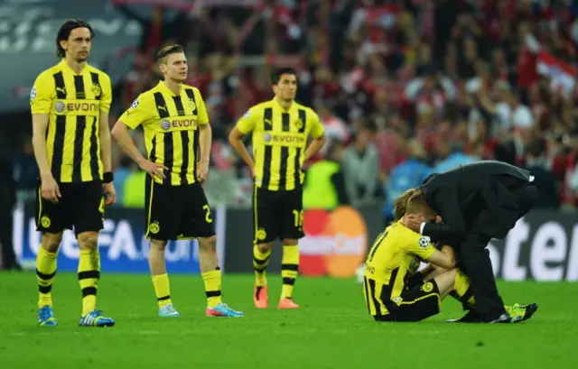 Neven Subotic, Lukasz Piszczek and Nuri Sahin of Borussia Dortmund look on as Marco Reus is consoled by Head Coach Jurgen Klopp