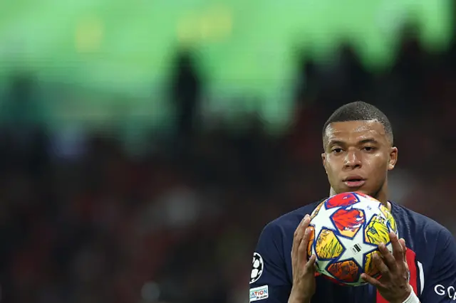 Kylian Mbappe holds the match ball