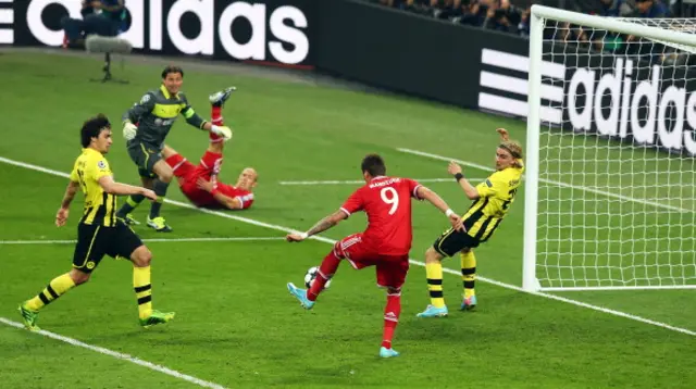 Mario Mario Mandzukic of Bayern Munich scores a goal past Marcel Schmelzer of Borussia Dortmund in the 2013 Champions League final