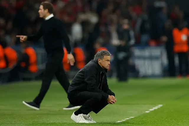 Luis Enrique crouches down on the touchline