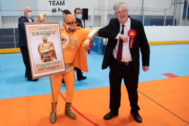 Welsh First Minister Mark Drakeford touches elbows with candidate Captain Beany after winning the Cardiff West constituency