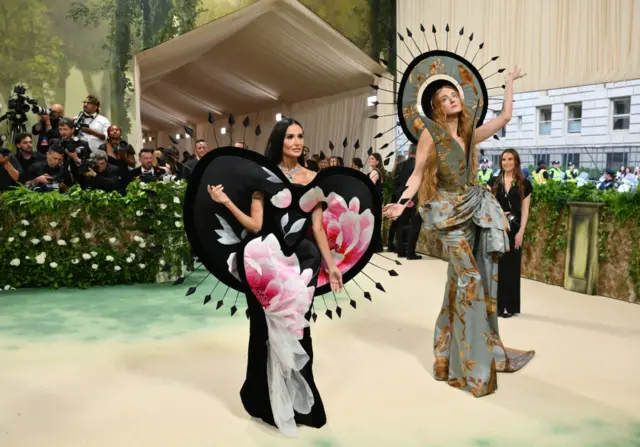 US actress Demi Moore (L) and US-British fashion designer Harris Reed arrive for the 2024 Met Gala at the Metropolitan Museum of Art on May 6, 2024, in New York