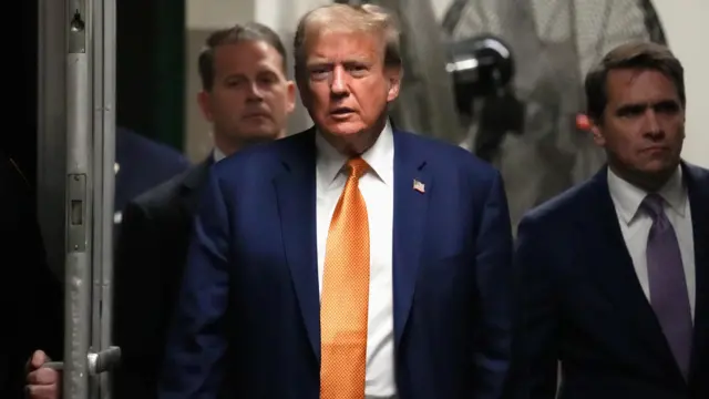 Trump walks through doors wearing gold tie