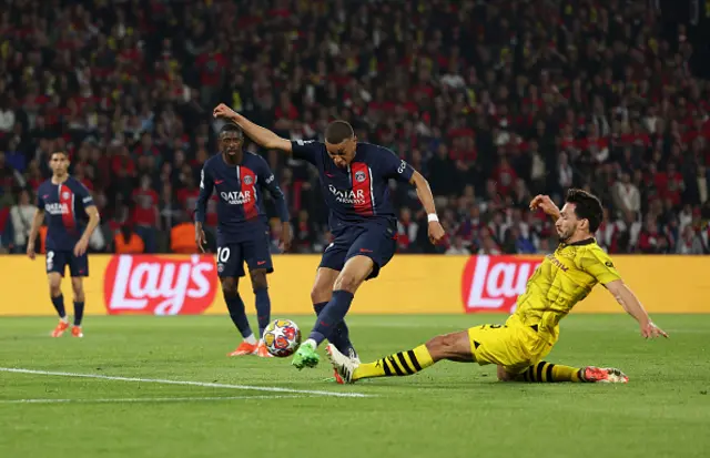 Kylian Mbappe of Paris Saint-Germain shoots whilst under pressure from Mats Hummels