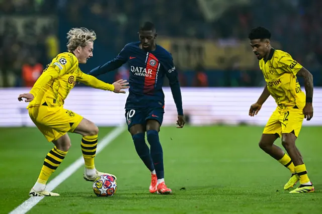 Julian Brandt (L) and Paris Saint-Germain's French forward Ousmane Dembele (C) fight for the ball