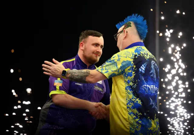 Luke Littler shakes Peter Wright's hand