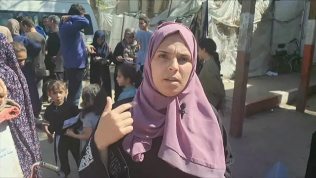 A Palestinian woman in a purple hijab speaks to the BBC in a field hospital after fleeing Rafah