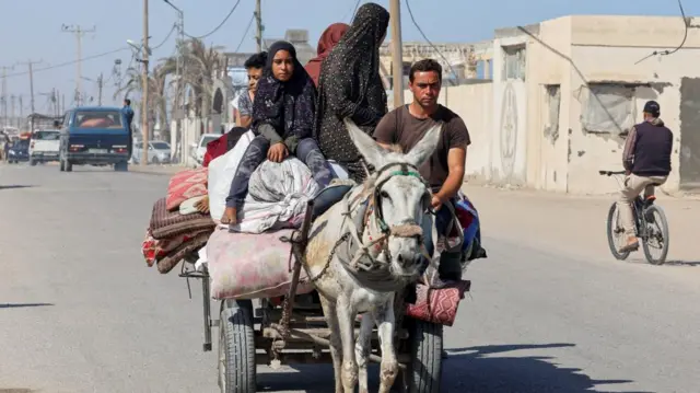 Palestinians travel in a donkey-drawn cart as they flee Rafah