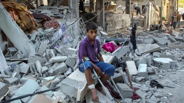 A wounded Palestinian sits on debri at the site of an Israeli strike on a house, amid the ongoing conflict between Israel and the Palestinian Islamist group Hamas, in Rafah, in the southern Gaza Strip May 9, 2024.