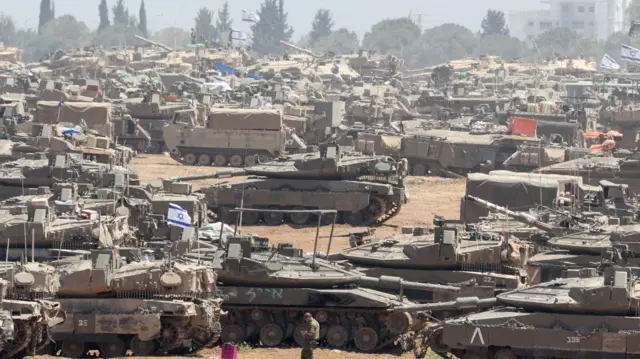 Military vehicles gather near the border fence with the Gaza Strip, in southern Israel