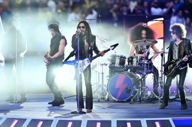 Lenny Kravitz performs before kick off on the pitch