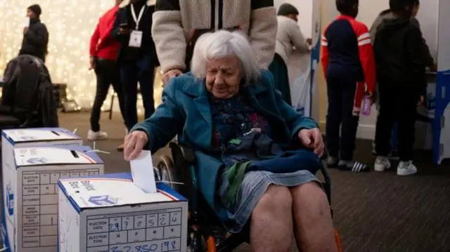 An elderly lady in a wheelchair casts her vote at the Killarney Country Club in Johannesburg, South Africa May 29, 2024