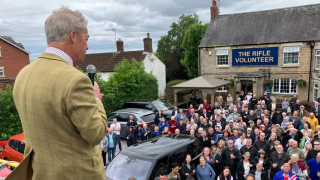 Nigel Farage speaking from the top of Reform UK's campaign bus