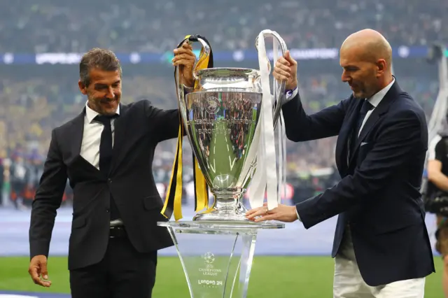 Zidane and Reidle bring the trophy onto the pitch