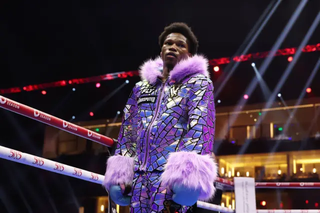 Raymond Ford in a purple, glittering ring outfit with fur on neck and sleeves