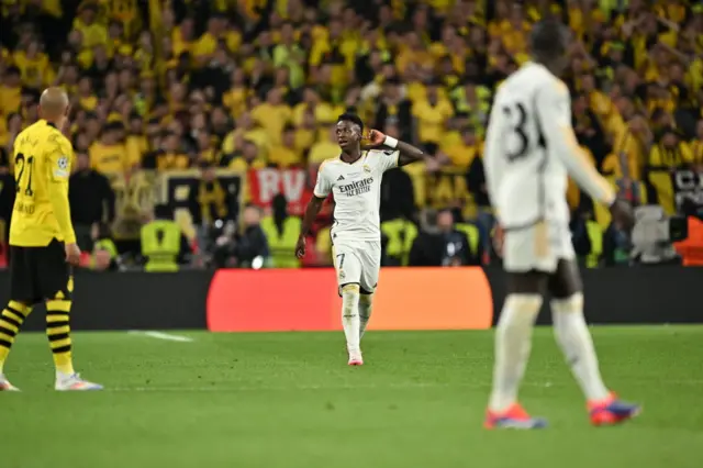 Vinicius cups his ear to the stadium after scoring the second