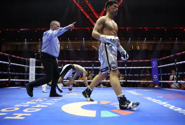 Dimitry Bivol is pointed away by the referee after knocking down his opponent