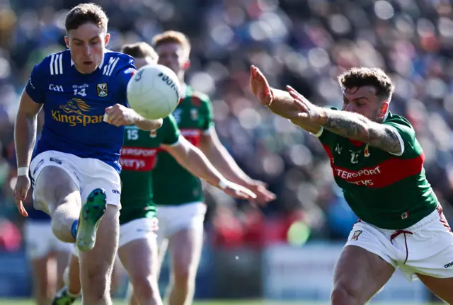 Cavan forward Cormac O'Reilly gets his shot away as Mayo's Jordan Flynn attempts to make the block