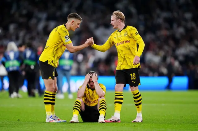 Dortmund players commiserate one another at full time