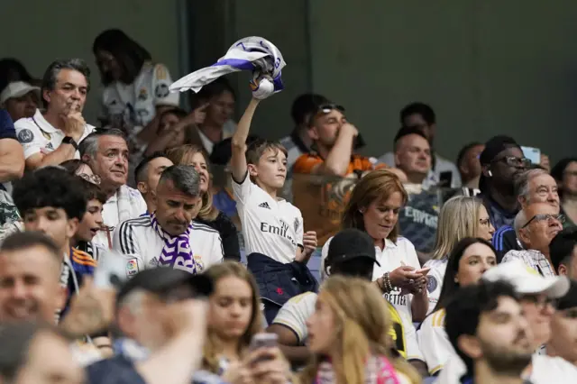 A young fan waves a scarf in the air before the game