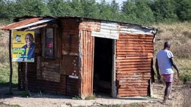 An ANC poster hangs on a burnt shack in a small village on May 31, 2024, in Qubuka, South Africa