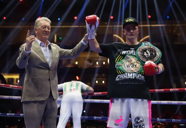 Frank Warren holds up the arm of Willy Hutchinson