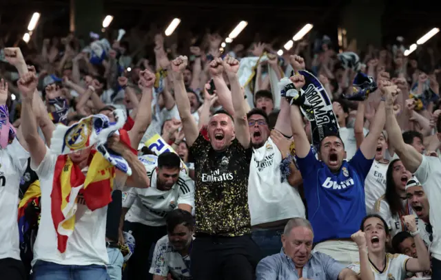 A madrid fan gets ready toc elebrste ith a tinfoil trophy