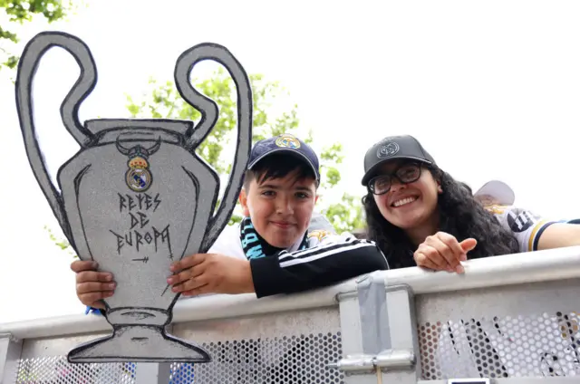 Fan holds up a cardboard trophy with 'Kings of Europe' written on it