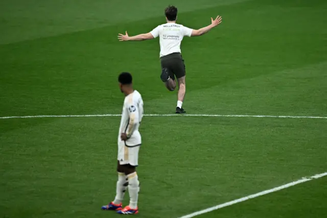 Bellingham watches on as a pitch invader runs onto the field