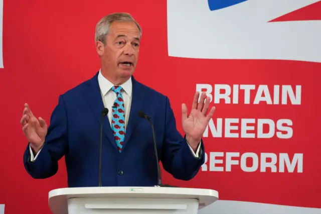 Nigel Farage speaks from a podium at a Reform UK campaign event