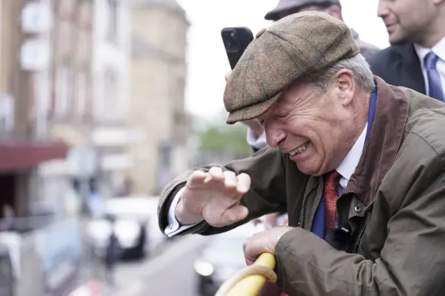 Reform UK leader Nigel Farage reacts after something is thrown towards him on the Reform UK campaign bus, 11 June 2024