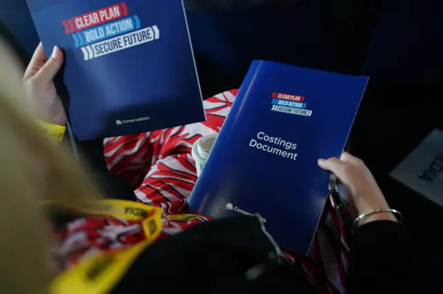 A woman holds the two documents