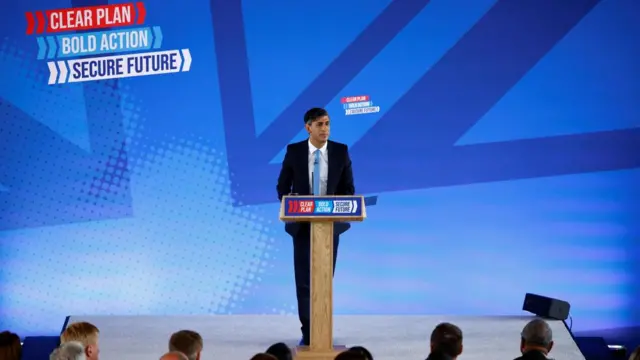 Rishi Sunak stands at a podium while unveiling the Conservative manifesto