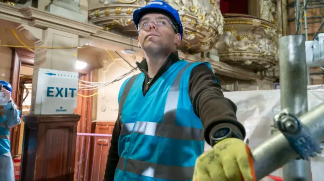 Douglas Ross wearing a hi-viz vest, helmet and goggles in a the Kings Theatre in Edinburgh